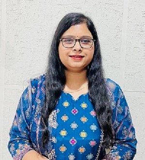 Portrait of Dr. Kapoor wearing traditional attire with academic books in background